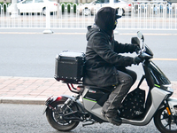 A citizen rides in thick clothes as temperatures plummet in Beijing, China, on October 19, 2024. (