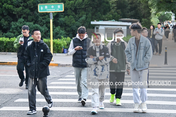 Citizens walk in thick clothes as temperatures plummet in Beijing, China, on October 19, 2024. 