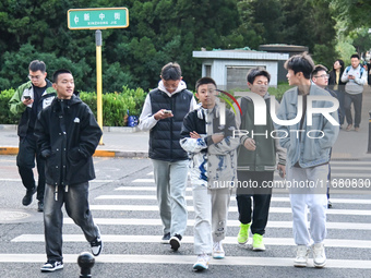 Citizens walk in thick clothes as temperatures plummet in Beijing, China, on October 19, 2024. (