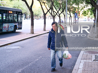 A citizen walks in thick clothes as temperatures plummet in Beijing, China, on October 19, 2024. (