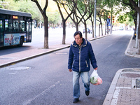 A citizen walks in thick clothes as temperatures plummet in Beijing, China, on October 19, 2024. (