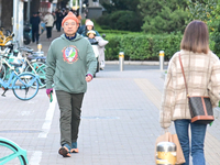 Citizens walk in thick clothes as temperatures plummet in Beijing, China, on October 19, 2024. (