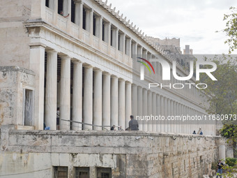 People explore the old town in Athens, Greece, on October 19, 2024. (