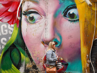 A woman walks past graffiti in Athens, Greece, on October 19, 2024. (