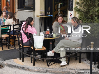 People drink coffee in Athens, Greece, on October 19, 2024. (