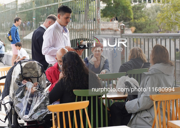 A waiter serves at a cafe in Athens, Greece, on October 19, 2024. 