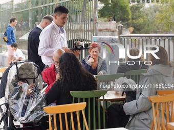 A waiter serves at a cafe in Athens, Greece, on October 19, 2024. (