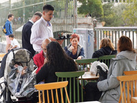 A waiter serves at a cafe in Athens, Greece, on October 19, 2024. (