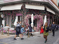 People walk past a coffee shop in Athens, Greece, on October 19, 2024. (