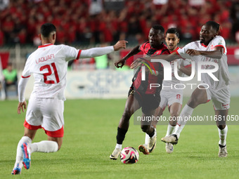 Tagnouo Mbe Jacques Amour of CR Belouizdad (R) competes for the ball with Likonza Adango Glody (C) of USM Alger during the football match be...