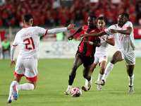 Tagnouo Mbe Jacques Amour of CR Belouizdad (R) competes for the ball with Likonza Adango Glody (C) of USM Alger during the football match be...