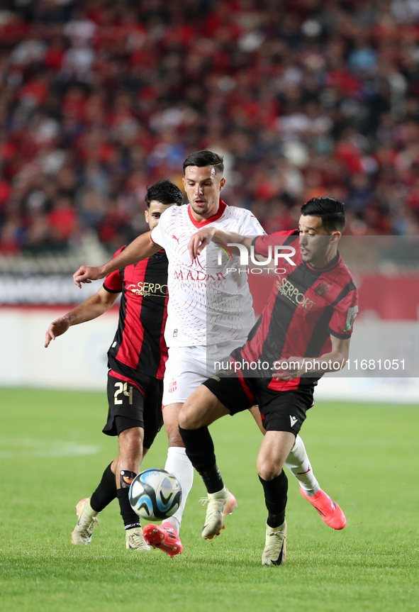 Daibeche Oussama of CR Belouizdad (center) fights for the ball with Khaled Bousseliou (right) of USM Alger during the football match between...