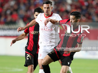 Daibeche Oussama of CR Belouizdad (center) fights for the ball with Khaled Bousseliou (right) of USM Alger during the football match between...