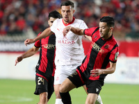 Daibeche Oussama of CR Belouizdad (center) fights for the ball with Khaled Bousseliou (right) of USM Alger during the football match between...