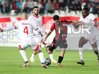 Tagnouo Mbe Jacques Amour of CR Belouizdad (R) fights for the ball with Ait el Hadj Mohamed (C) of USM Alger during the football match betwe...