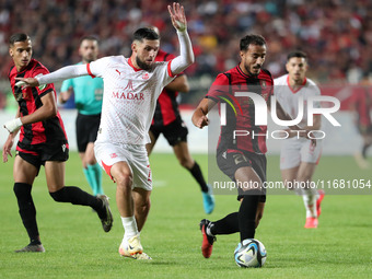 Chaabi Hedy of CR Belouizdad (left) fights for the ball with Allilet Adem (right) of USM Alger during the football match between CR Belouizd...