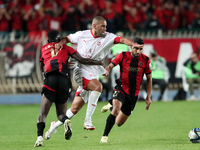 Islam Slimani of CR Belouizdad (C) competes for the ball with Likonza Adango Glody (L) of USM Alger during the football match between CR Bel...