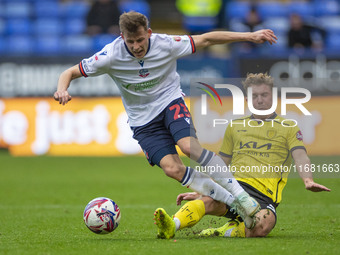 Szabolcs Schon #23 of Bolton Wanderers F.C. is tackled by Ben Whitfield #34 of Burton Albion F.C. during the Sky Bet League 1 match between...