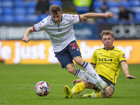 Szabolcs Schon #23 of Bolton Wanderers F.C. is tackled by Ben Whitfield #34 of Burton Albion F.C. during the Sky Bet League 1 match between...