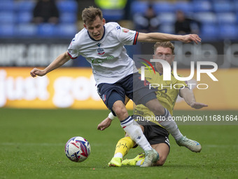 Szabolcs Schon #23 of Bolton Wanderers F.C. is tackled by Ben Whitfield #34 of Burton Albion F.C. during the Sky Bet League 1 match between...