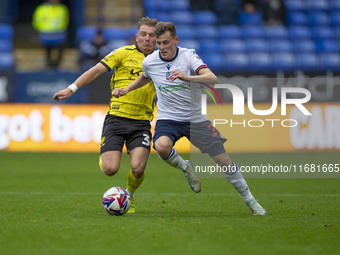 Szabolcs Schon #23 of Bolton Wanderers F.C. is tackled by Ben Whitfield #34 of Burton Albion F.C. during the Sky Bet League 1 match between...