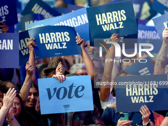 Waterford, MICHIGAN - OCTOBER 18: Attendees hold signs at the rally for US Vice President and Democratic presidential candidate Kamala Harri...