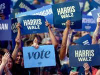 Waterford, MICHIGAN - OCTOBER 18: Attendees hold signs at the rally for US Vice President and Democratic presidential candidate Kamala Harri...