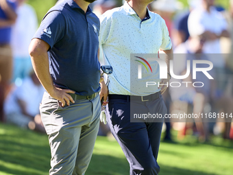 In San Roque, Spain, on October 19, 2024, Jon Rahm of Spain talks with Bernd Wiesberger of Austria on the 14th green on the third day of the...