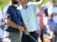 In San Roque, Spain, on October 19, 2024, Jon Rahm of Spain talks with Bernd Wiesberger of Austria on the 14th green on the third day of the...