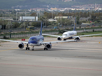 An Airbus A319-111 from Azerbaijan Airlines and a Boeing 737-8AS from Ryanair prepare for takeoff on the runway at Barcelona Airport in Barc...