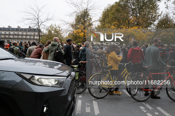 An SUV passes by the protesters during a gathering at the Place de La Republique in Paris, France, on October 19, 2024, to pay tribute to Pa...