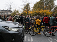 An SUV passes by the protesters during a gathering at the Place de La Republique in Paris, France, on October 19, 2024, to pay tribute to Pa...