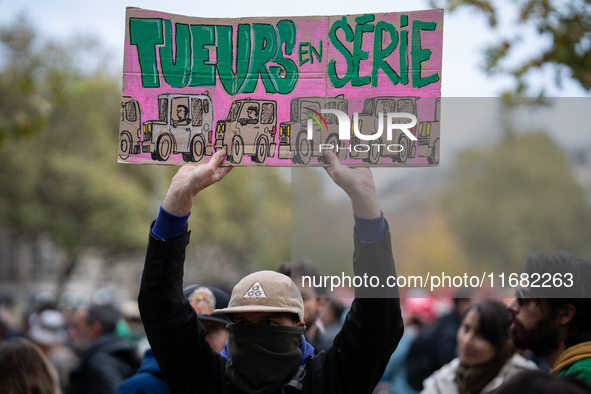 A man holds a sign reading ''serial killers'' during a gathering at the Place de La Republique in Paris, France, on October 19, 2024, to pay...