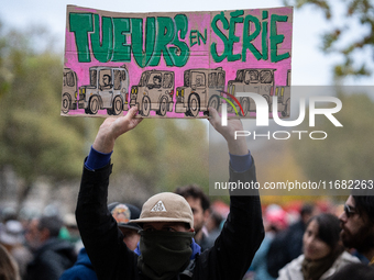 A man holds a sign reading ''serial killers'' during a gathering at the Place de La Republique in Paris, France, on October 19, 2024, to pay...