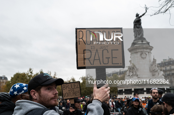 A man holds a sign reading ''road rage is just rage'' during a gathering at the Place de La Republique in Paris, France, on October 19, 2024...