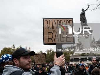 A man holds a sign reading ''road rage is just rage'' during a gathering at the Place de La Republique in Paris, France, on October 19, 2024...