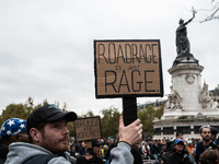 A man holds a sign reading ''road rage is just rage'' during a gathering at the Place de La Republique in Paris, France, on October 19, 2024...