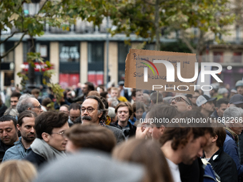 A man holds a sign reading ''police officers don't let us down stop motorised violence'' during a gathering at the Place de La Republique in...