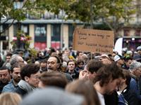 A man holds a sign reading ''police officers don't let us down stop motorised violence'' during a gathering at the Place de La Republique in...