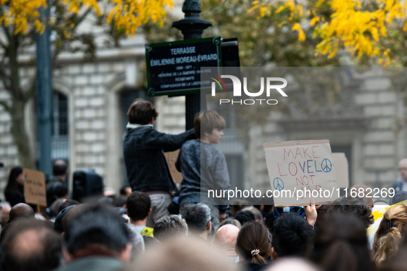 A demonstrator holds a sign reading ''make love not war'' during a gathering at the Place de La Republique in Paris, France, on October 19,...