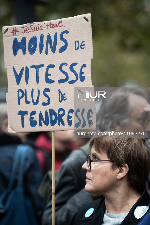 A woman holds a sign reading ''less speed more tenderness'' during a gathering at the Place de La Republique in Paris, France, on October 19...