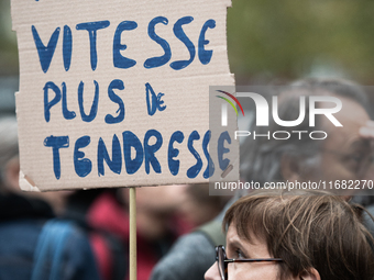 A woman holds a sign reading ''less speed more tenderness'' during a gathering at the Place de La Republique in Paris, France, on October 19...