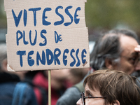 A woman holds a sign reading ''less speed more tenderness'' during a gathering at the Place de La Republique in Paris, France, on October 19...