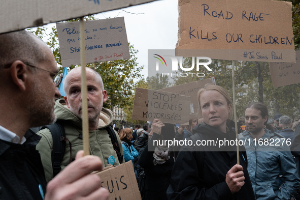 People hold signs during a gathering at the Place de La Republique in Paris, France, on October 19, 2024, to pay tribute to Paul, a 27-year-...