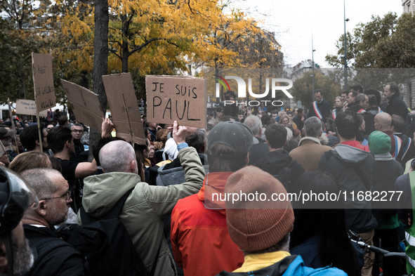 A man holds a sign reading ''I am Paul'' during a gathering at the Place de La Republique in Paris, France, on October 19, 2024, to pay trib...