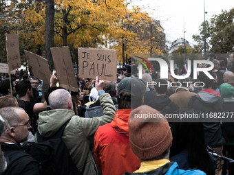 A man holds a sign reading ''I am Paul'' during a gathering at the Place de La Republique in Paris, France, on October 19, 2024, to pay trib...