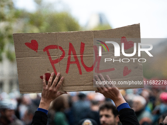 A man holds a sign reading ''Paul'' during a gathering at the Place de La Republique in Paris, France, on October 19, 2024, to pay tribute t...