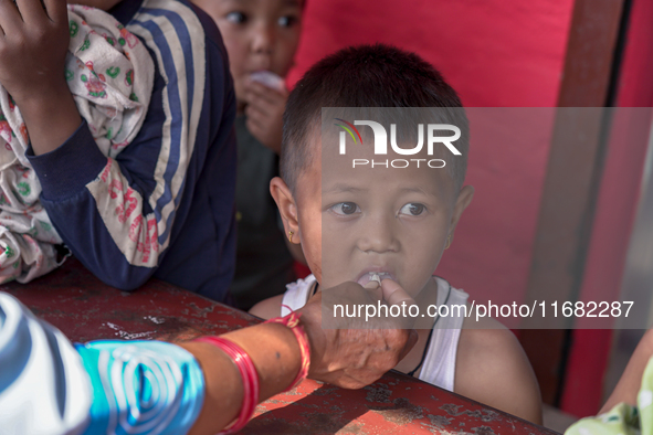 A health worker gives a Vitamin A capsule to a child in Dhading, Nepal, on October 19, 2024. 