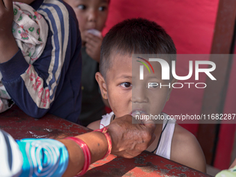 A health worker gives a Vitamin A capsule to a child in Dhading, Nepal, on October 19, 2024. (