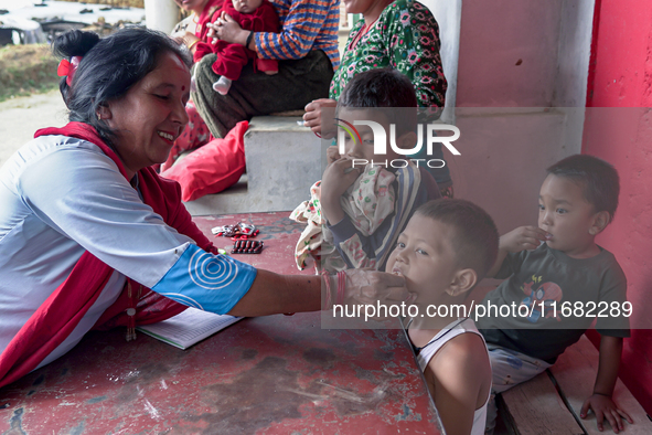 A health worker gives a Vitamin A capsule to a child in Dhading, Nepal, on October 19, 2024. 